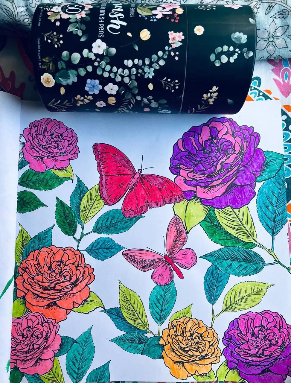 A colouring page of roses and butterflies, worked in pink, purple, orange and teal